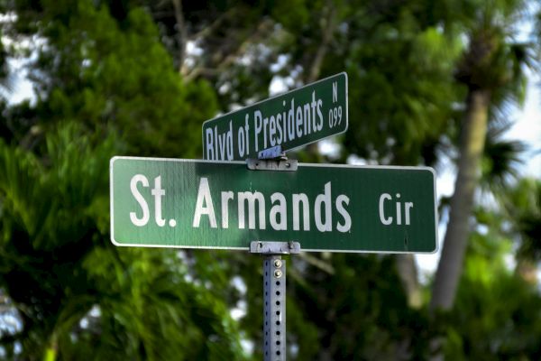 Street signs reading "Blvd of Presidents" and "St. Armands Cir" against a backdrop of lush greenery.