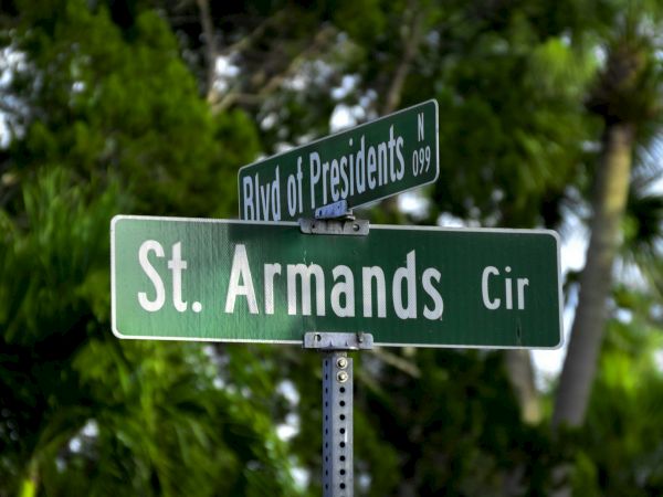 Street signs reading "Blvd of Presidents" and "St. Armands Cir" against a backdrop of lush greenery.