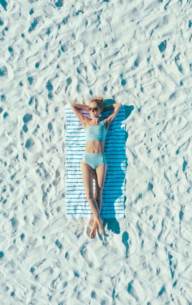 woman laying on beach towel